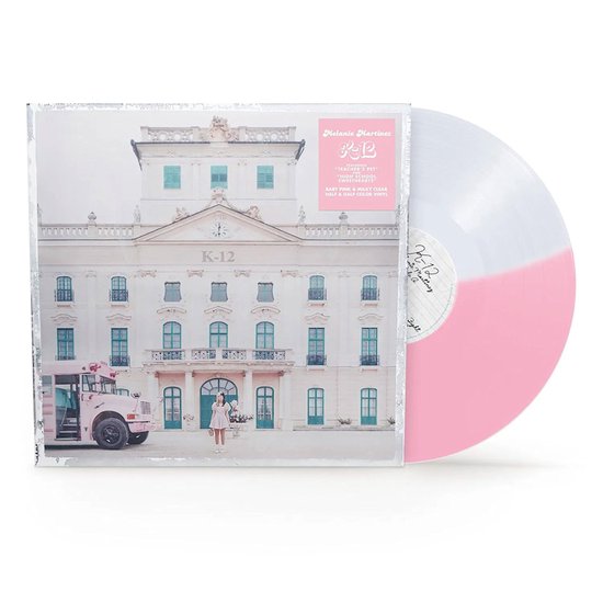 De K-12 vinylplaat heeft een half roze, half witte kleur. De hoes toont Melanie Martinez voor een pastelroze schoolbus en een gebouw met de tekst K-12.
