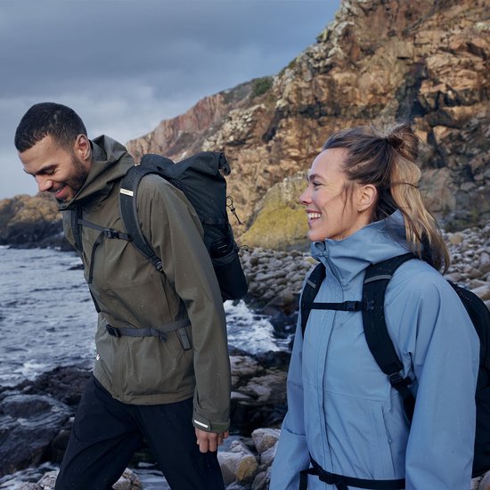 Un homme et une femme portant des sacs à dos, tous deux vêtus de vestes d'extérieur dans un environnement naturel.