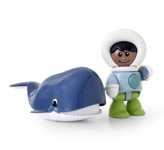 Blauwe speelgoedwalvis naast een figuur in een witte parka met bontkraag, een lichtblauwe jas en groene laarzen.