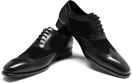 Twee zwarte leren veterschoenen met suède panelen en wingtip details.