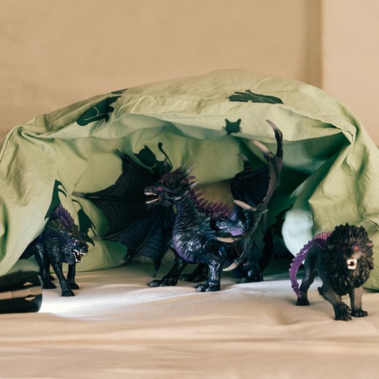 Zwarte draak, met paarse vleugels, nek en rug, grijze schubben, samen met andere speelgoeddieren.