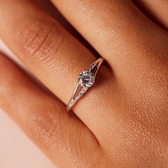 Close-up van een damesring van 925 zilver met zirkonia aan een vinger.