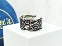Zilverkleurige ring met Viking Raven patroon, op een witte kubus.