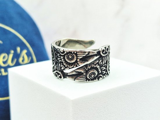 Zilverkleurige ring met Viking Raven patroon, op een witte kubus.