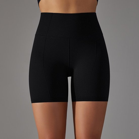 Zwarte, nauwsluitende biker shorts met hoge taille en subtiel textuurpatroon, gedragen door een model.
