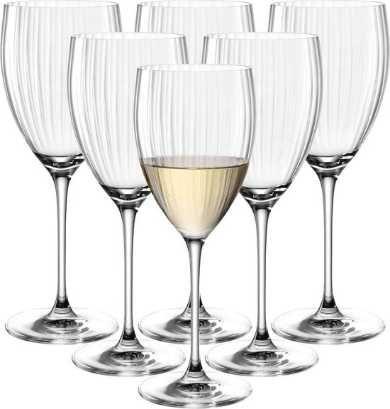 Zes glazen met verticale ribbels, één glas is gevuld met witte wijn.