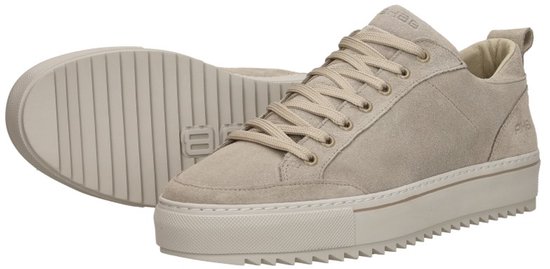 Paar crème suède lage sneakers met beige veters en dikke geribbelde zool.