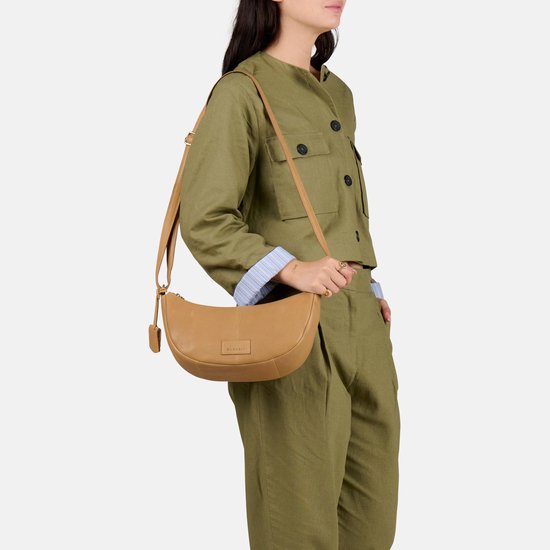 Model met lichtbruine Burkely crossbody tas om de schouder, van soepel leer.