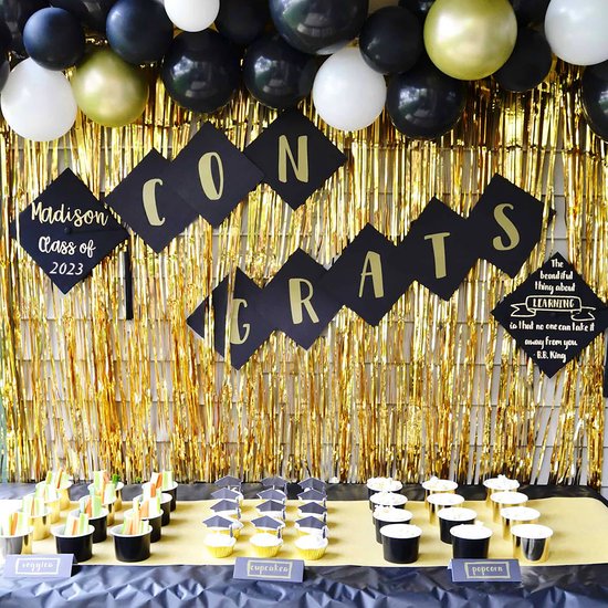 Gouden glittergordijn achter een feesttafel met cupcakes en 'Congrats' slinger.
