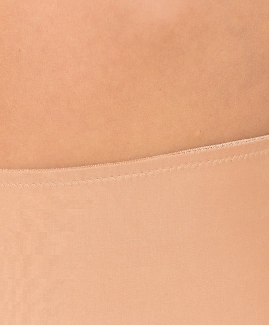 Detail van de naad van de tailleband van een huidskleurige corrigerende short.