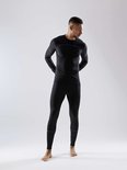 Man in zwart thermoshirt en legging, met grijze details op shirt en broek, ribbelstructuur.