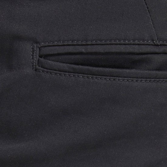 Close-up van een zwarte chino broek met een paspelzak.