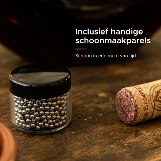 Petite bouteille en verre avec des perles de nettoyage argentées, à côté d'un bouchon de vin.