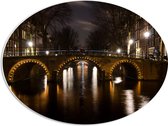 PVC Schuimplaat Ovaal - Verlichte Amsterdamse Gracht in de Nacht - 56x42 cm Foto op Ovaal (Met Ophangsysteem)