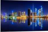 PVC Schuimplaat- Skyline van Dubai met Weerspiegeling in de Zee, Qatar - 90x60 cm Foto op PVC Schuimplaat