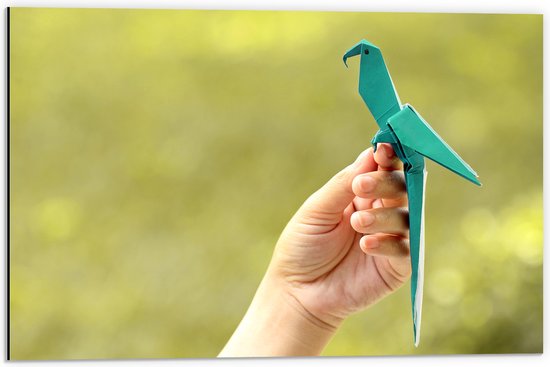 Dibond - Blauwe Origami Vogel op Hand van Mens in Groene Omgeving - 60x40 cm Foto op Aluminium (Met Ophangsysteem)