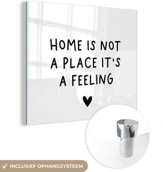 MuchoWow® Glasschilderij 50x50 cm - Schilderij acrylglas - Engelse quote "Home is not a place it's a feeling" met een hartje op een witte achtergrond - Foto op glas - Schilderijen