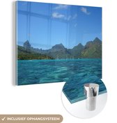 MuchoWow® Glasschilderij 80x60 cm - Schilderij acrylglas - De 'Ōpūnohu baai in Moorea met een bergachtige achtergrond - Foto op glas - Schilderijen