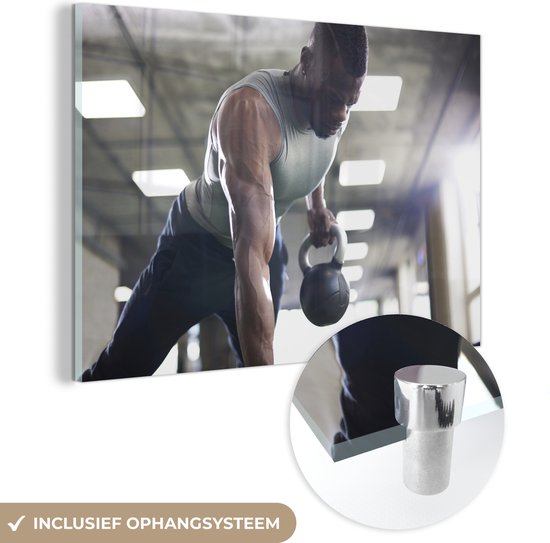 MuchoWow® Glasschilderij 60x40 cm - Schilderij acrylglas - Een sterke man tilt tijdens fitness kettlebells omhoog - Foto op glas - Schilderijen