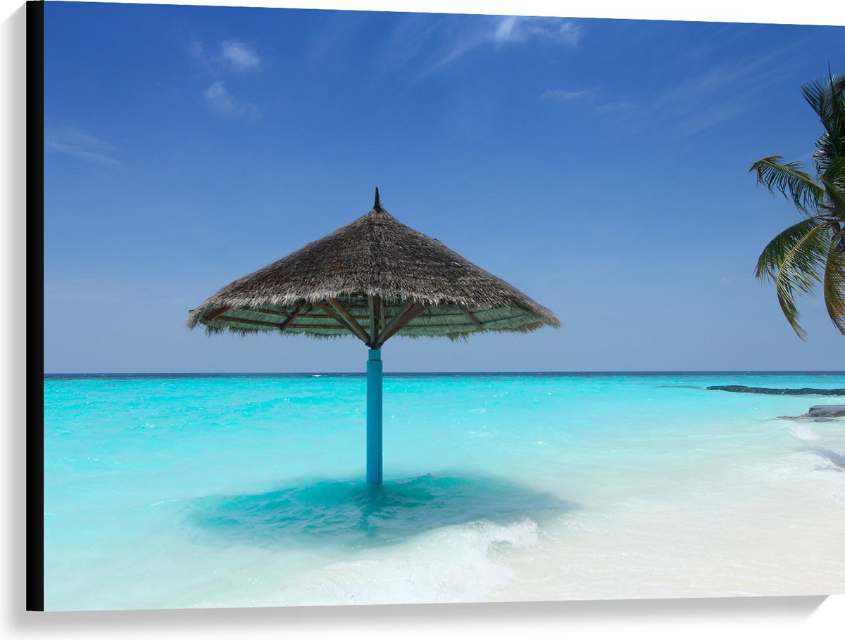 Canvas - Rieten Parasol op het Strand bij het Blauwe Water - 100x75 cm Foto op Canvas Schi