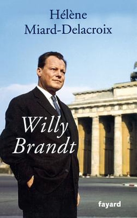 Willy Brandt en costume sombre avec cravate, devant la Porte de Brandebourg.