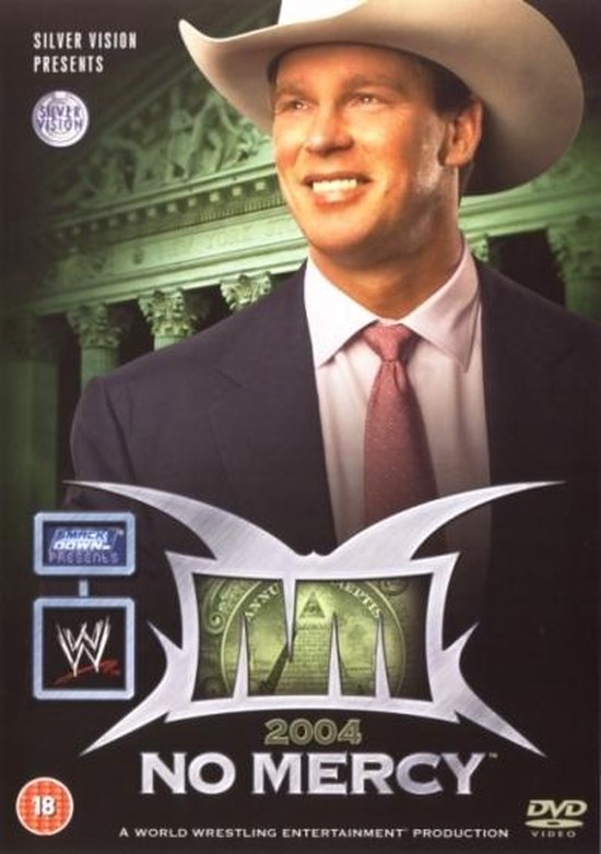 Een man met een cowboyhoed en een pak met een roze stropdas, lachend. De tekst 'WWE NO MERCY 2004' staat vooraan.