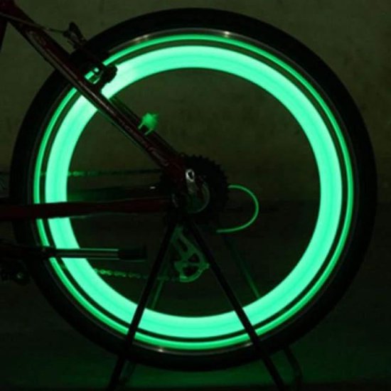 Groene spaakverlichting op een fietswiel, die een heldere cirkel vormt.