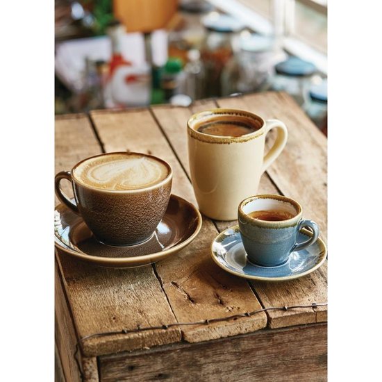 Drie mokken op een houten tafel: een grote cappuccino met latte art, een beige mok met koffie en een kleine blauwe mok.
