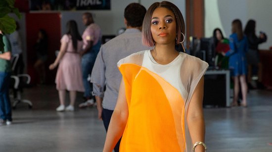 Regina Hall in een modieus wit top met een oranje, geplooide overlay.