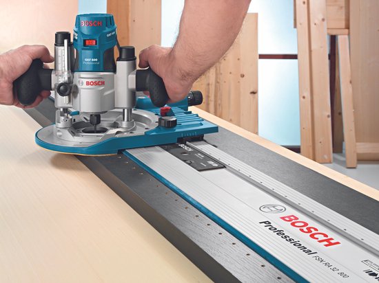 Bosch GKF 600 bovenfrees met geleiderail FSN RA 32 800, met twee handen aan de machine.