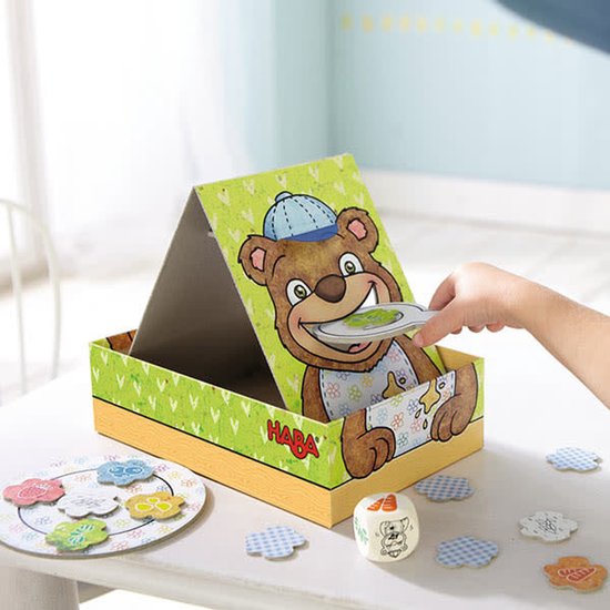 Kind speelt met HABA Bärnhunger spel: beer met lepel en voer.