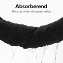 Een zwarte badmat die water absorbeert, met de tekst 'Absorberend' en 'Houd je vloer droog en veilig'.