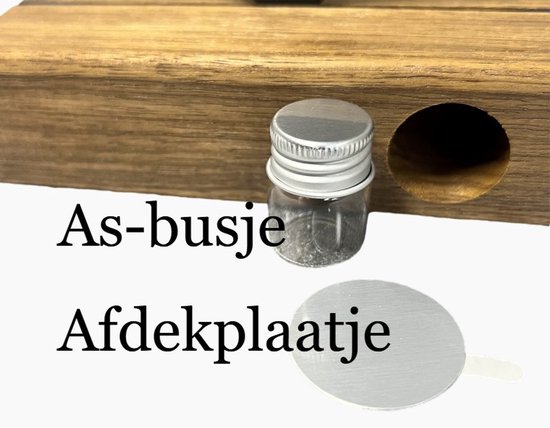 Een kleine glazen urn met een zilveren dopje en een "Afdekplaatje".