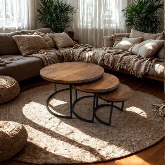 Een set van drie ronde, houten salontafels met metalen onderstel op een rond vloerkleed.