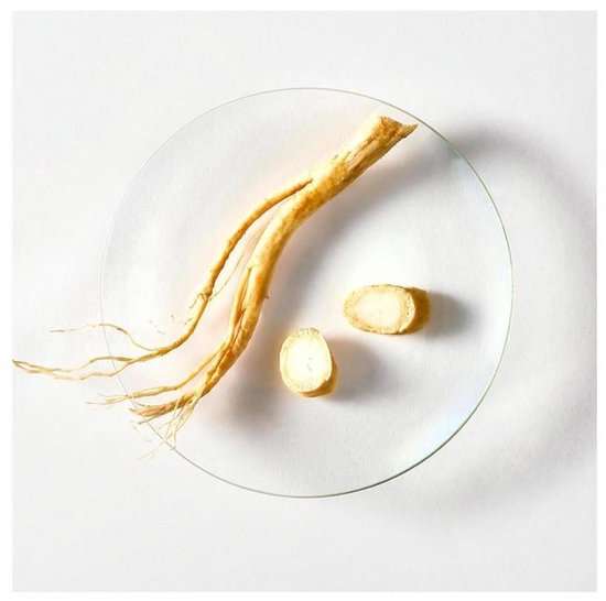 Een enkele ginsengwortel met twee plakjes op een glazen schaal.