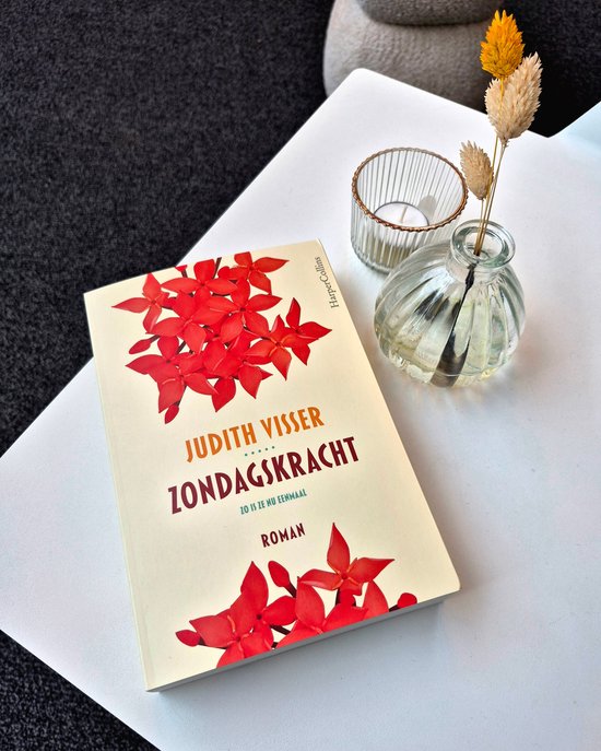 Boek met lichtgele kaft en rode Ixora bloemen. Titel: Zondagskracht van Judith Visser.