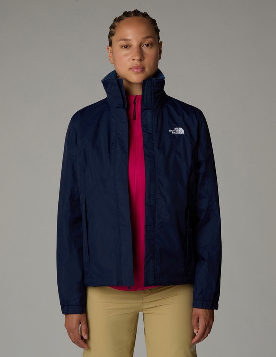 Dames in donkerblauwe The North Face jas over een fuchsia top en beige broek.
