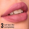 Gedetailleerde close-up van lippen met roze matte lippenstift. 'Let lips dry completely' is zichtbaar.