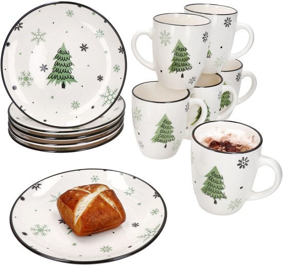 Kerstontbijtset met borden en mokken, versierd met groene kerstbomen en zwarte sneeuwvlokken op een witte achtergrond.