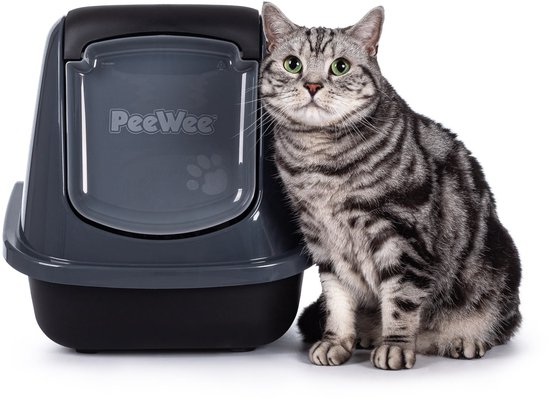 Donkergrijze kattenbak met klep en een zittende gestreepte kat ernaast.