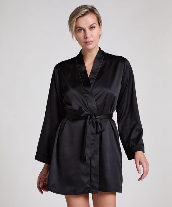 Model in zwarte satijnen kimono met ceintuur die in de taille is gestrikt.