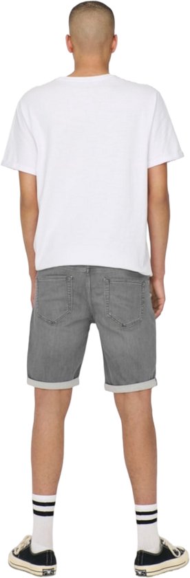 Achterkant van een man in een grijze denim short met omgeslagen broekspijpen.