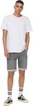 Volledige outfit van een man in een witte t-shirt en grijze denim shorts, met gestreepte sokken.