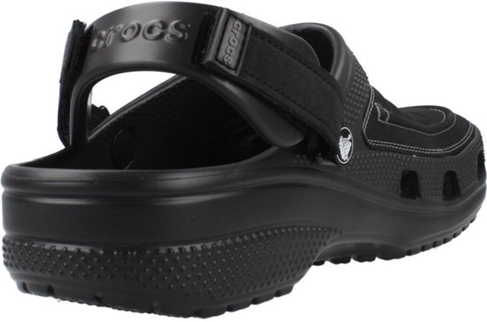 Achterkant van een zwarte Crocs klomp met een hengsel op de hak en logo.