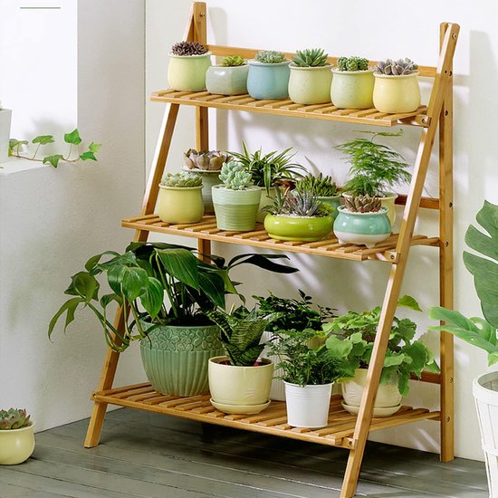 Houten plantenstandaard met drie etages, gevuld met diverse groene planten en succulenten in potten.