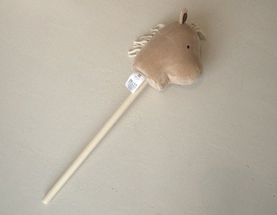 Een stokpaard met lichtbruin hoofd en witte manen van touw.