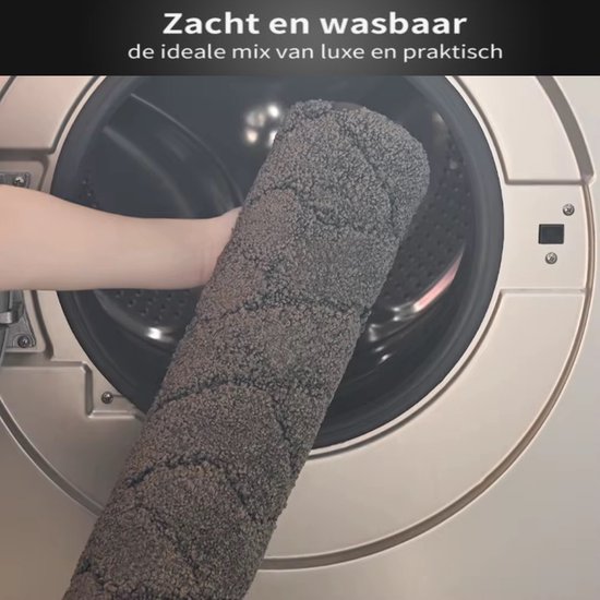 Grijze, zachte badmat die in de wasmachine gaat.