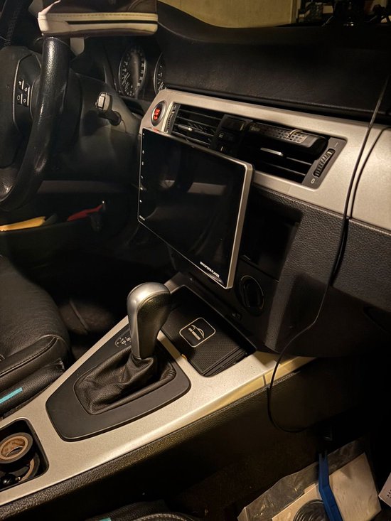 Autoradio gemonteerd in het dashboard van een auto, met de versnellingspook zichtbaar.