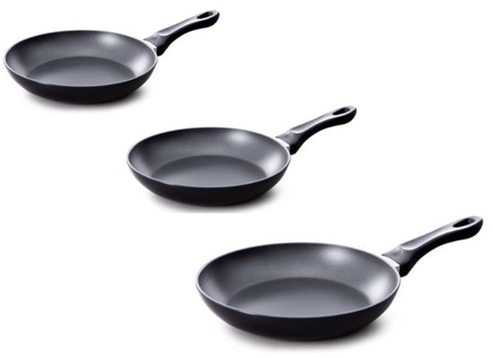 Trois poêles noires avec poignées noires, empilées.