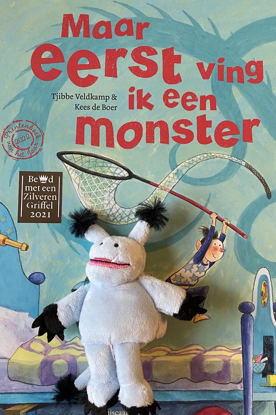 Boekomslag met de titel 'Maar eerst ving ik een monster'. Een wit monsterknuffel staat vooraan, met een schepnet en een jongen aan een slinger erachter.